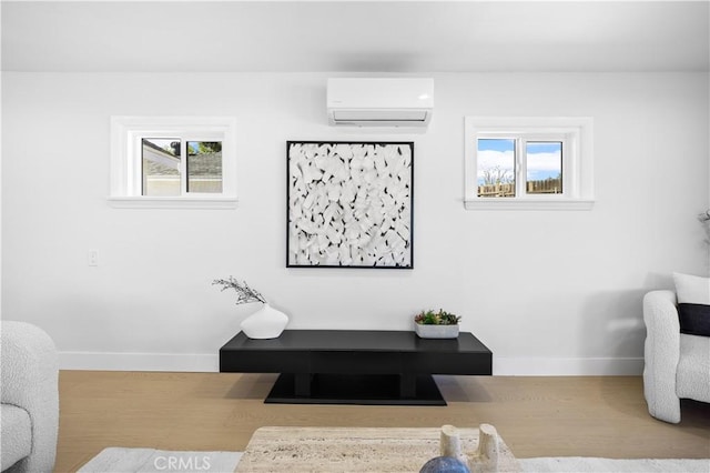 living room featuring an AC wall unit and hardwood / wood-style floors