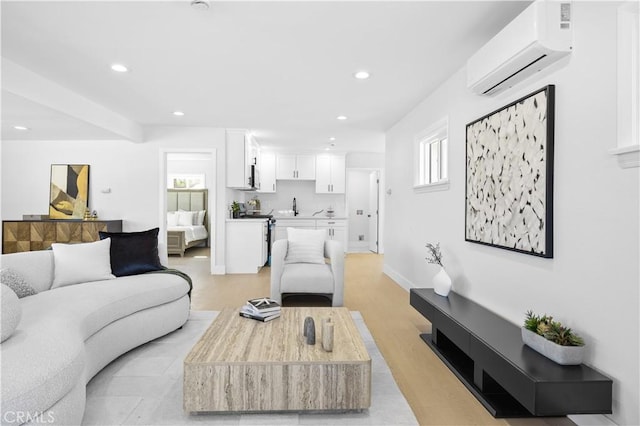 living room with light hardwood / wood-style floors, sink, and a wall unit AC