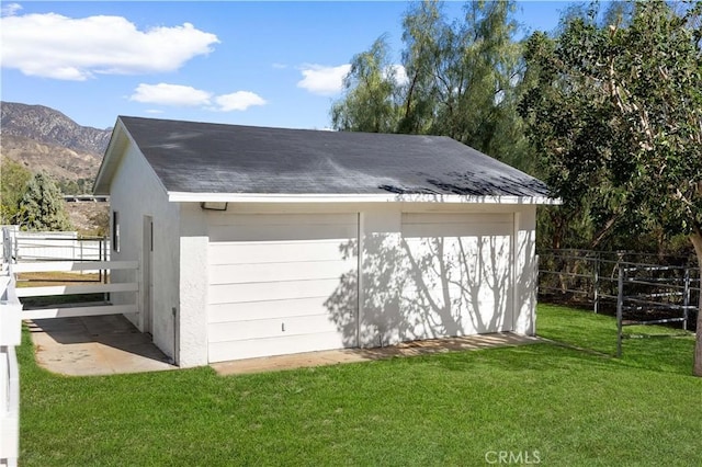 garage with a mountain view and a yard