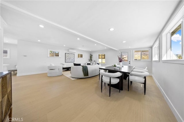 dining room with light wood-type flooring and a wall mounted AC