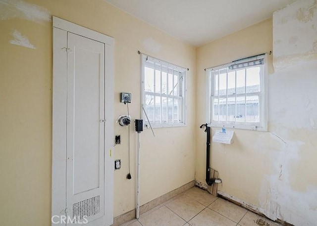 doorway to outside featuring baseboards and light tile patterned floors