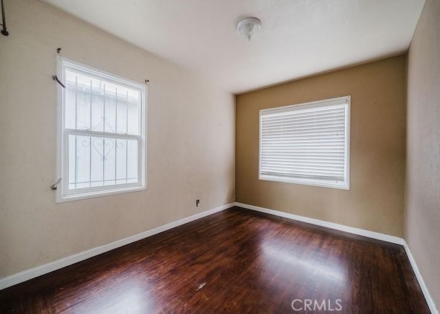 empty room with baseboards and wood finished floors