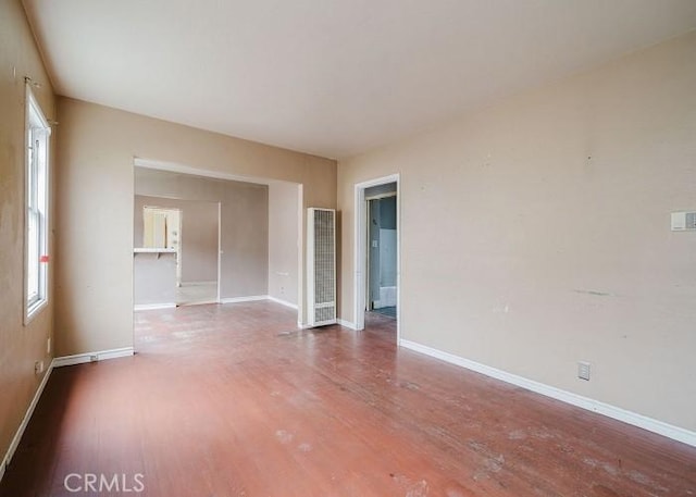 unfurnished room with baseboards and wood finished floors