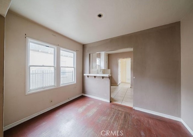 empty room with baseboards and light wood finished floors