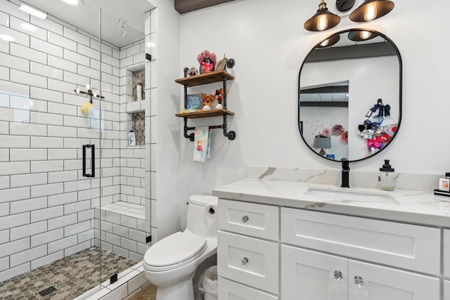 bathroom featuring toilet, vanity, and an enclosed shower