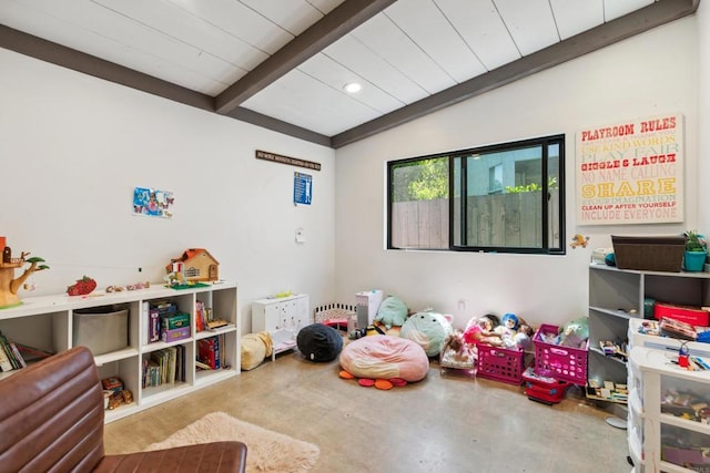 playroom with concrete floors and lofted ceiling with beams