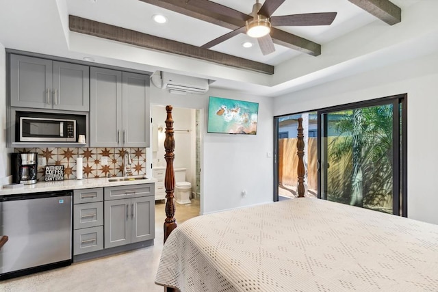 bedroom with sink, fridge, an AC wall unit, beamed ceiling, and access to exterior