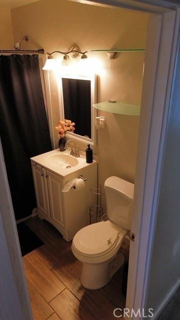 full bathroom featuring toilet, wood finished floors, and vanity