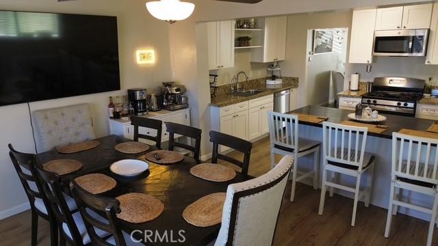 dining space with dark wood finished floors, a ceiling fan, and baseboards