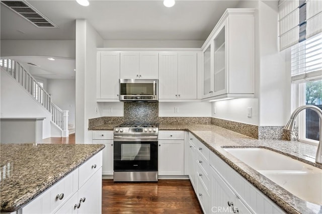 40241 Courtland Way, Temecula, CA 92591 - kitchen with appliances with stainless steel finishes, white cabinetry, dark stone counters, and sink