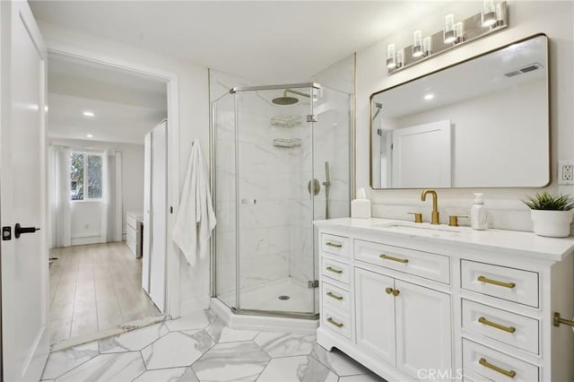 bathroom with vanity and a shower with door