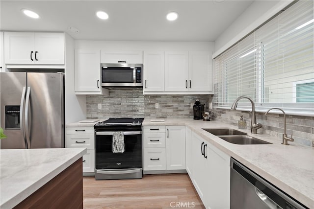 kitchen with white cabinets, a healthy amount of sunlight, stainless steel appliances, and sink