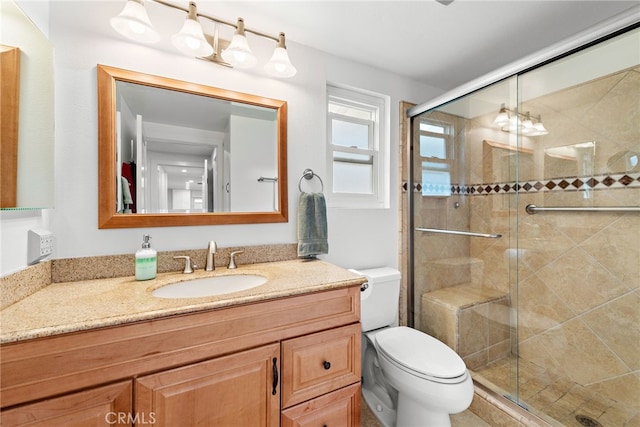 bathroom with an enclosed shower, vanity, and toilet