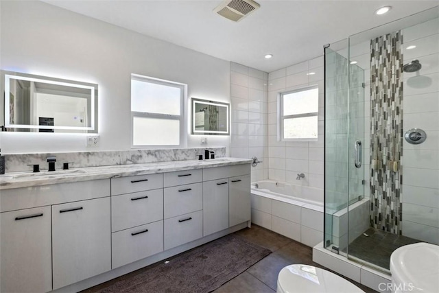 bathroom featuring plus walk in shower, vanity, and tile patterned flooring