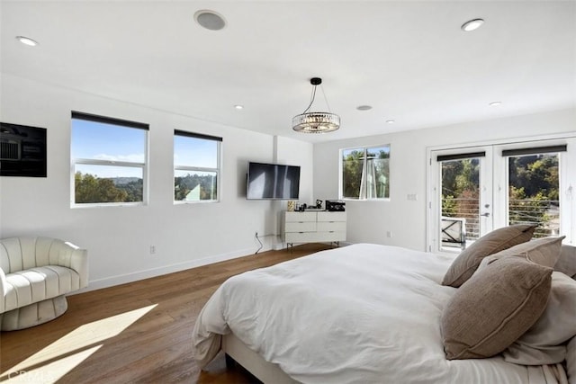 bedroom featuring dark wood-type flooring, access to outside, multiple windows, and french doors