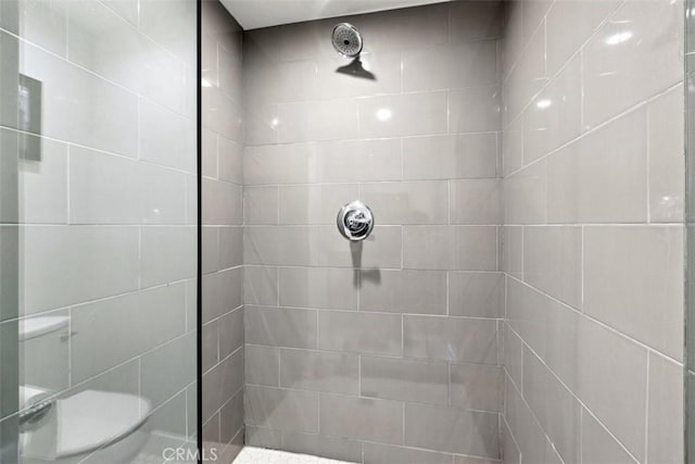 bathroom featuring toilet and tiled shower