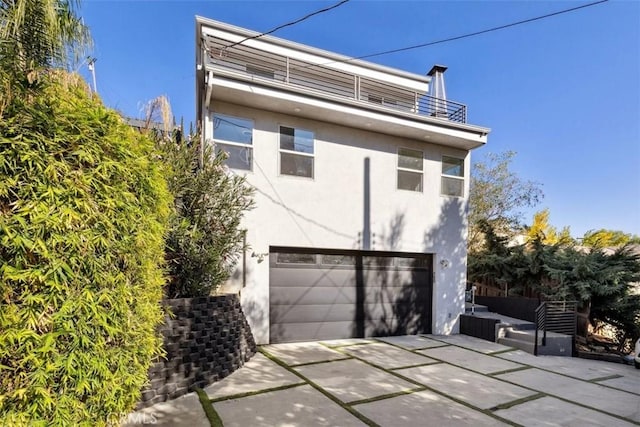 view of property exterior with a garage and a balcony