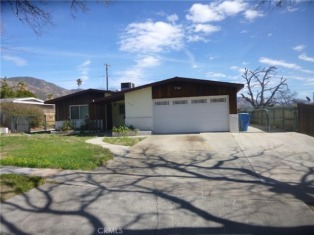 view of front facade featuring a gate, fence, brick siding, and an attached garage