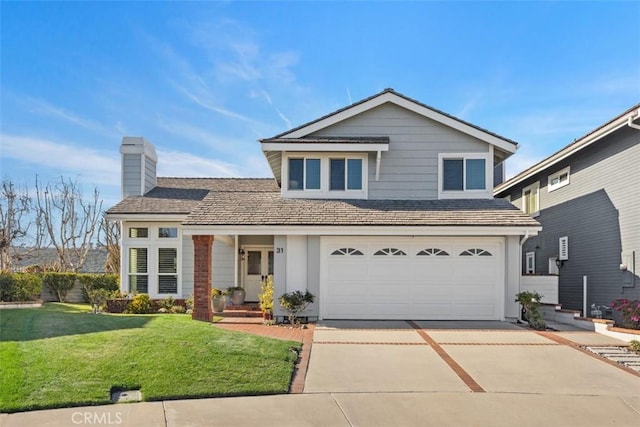 traditional home with a front yard, driveway, a chimney, and an attached garage