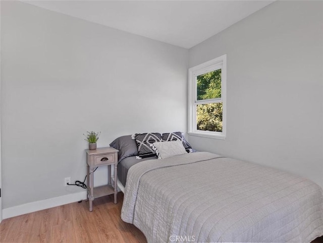 bedroom with light wood-style floors and baseboards