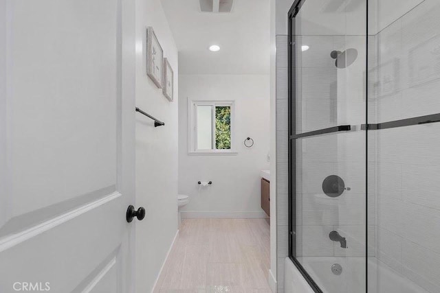 full bath featuring baseboards, visible vents, toilet, shower / bath combination with glass door, and vanity