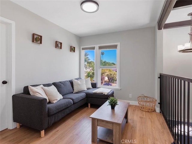 living room with beamed ceiling, wood finished floors, and baseboards