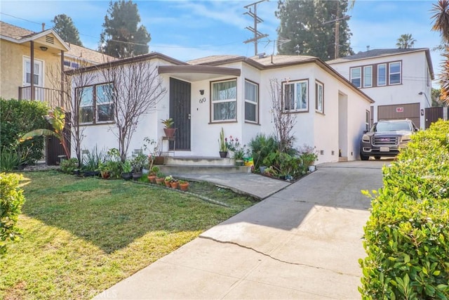 view of front of house with stucco siding, central AC, concrete driveway, and a front yard