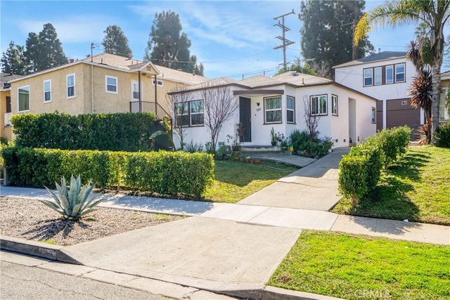 view of front facade featuring a front yard and stucco siding