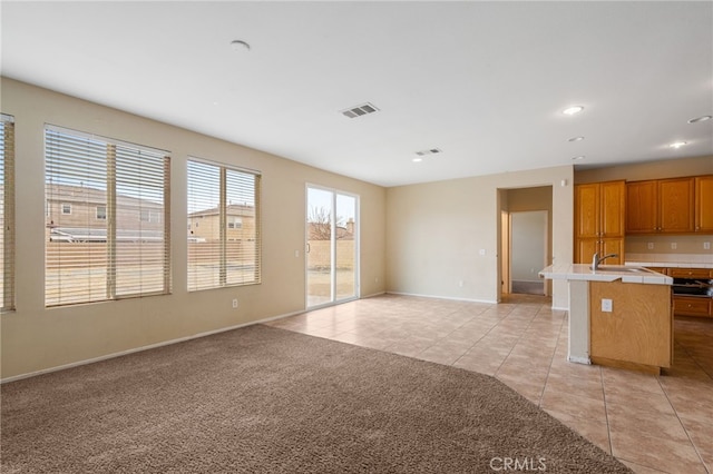 kitchen featuring light tile patterned floors and an island with sink