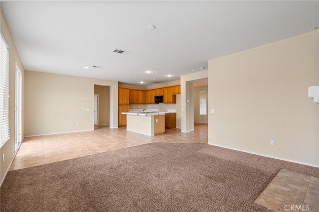 unfurnished living room featuring sink and light colored carpet