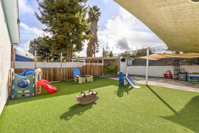 view of playground with a yard and a patio