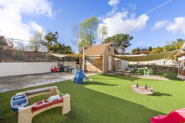 view of property's community featuring a patio, a lawn, and a storage unit