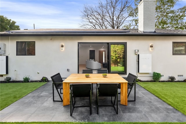 rear view of house with stucco siding, a lawn, outdoor dining space, crawl space, and a patio area