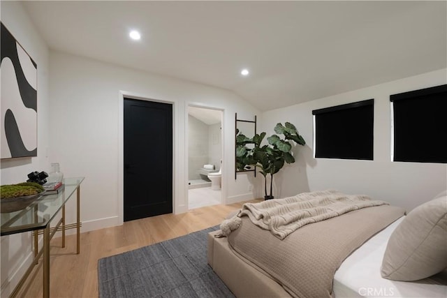 bedroom featuring baseboards, lofted ceiling, ensuite bathroom, light wood-style floors, and recessed lighting