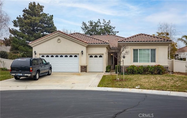 mediterranean / spanish home with concrete driveway, an attached garage, fence, and stucco siding