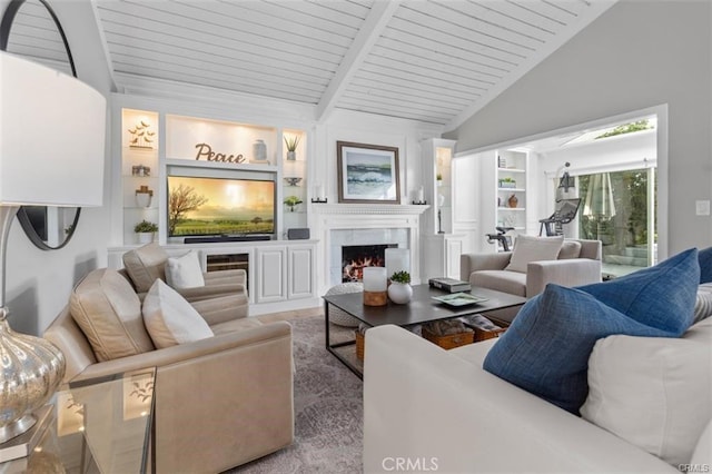 living area with lofted ceiling with beams, a warm lit fireplace, wood ceiling, and built in features