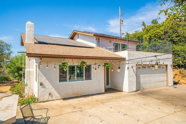 view of front of house featuring a garage and solar panels