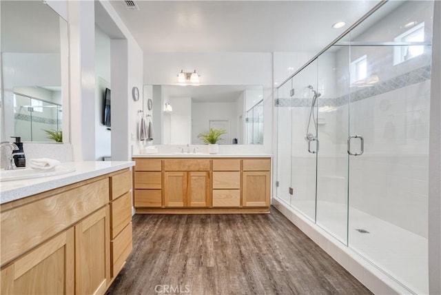 bathroom with hardwood / wood-style flooring, an enclosed shower, and vanity