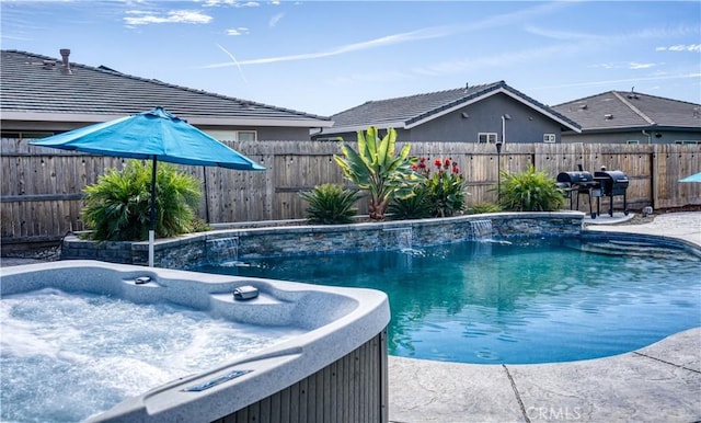 view of swimming pool featuring a grill and a hot tub