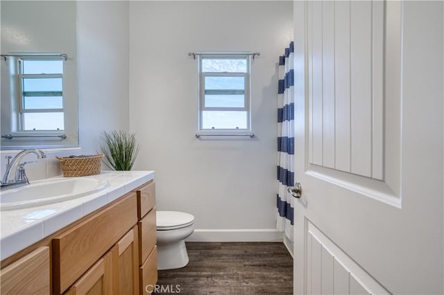 bathroom with toilet, vanity, and wood-type flooring