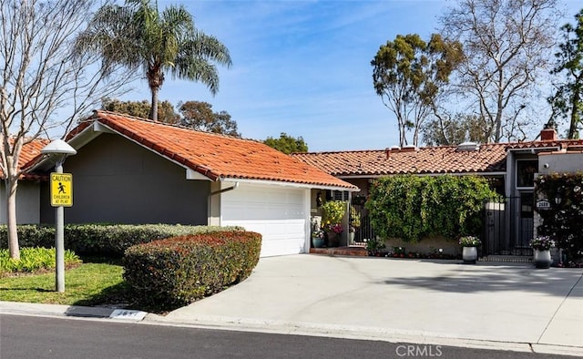 ranch-style home with driveway, a garage, and a tiled roof