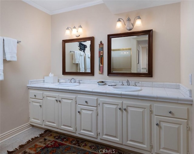 full bath featuring tile patterned flooring, ornamental molding, double vanity, and a sink