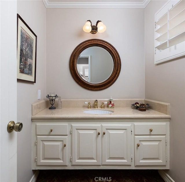 bathroom with baseboards, crown molding, and vanity