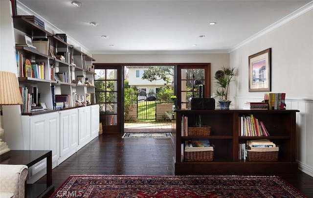 interior space with dark wood-type flooring, ornamental molding, and wainscoting