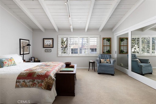 bedroom with rail lighting, carpet floors, vaulted ceiling with beams, and baseboards