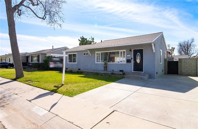 ranch-style home with stucco siding, driveway, a front yard, and a gate