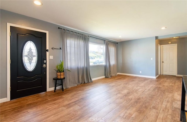 foyer entrance with light wood-type flooring and baseboards