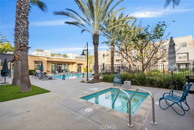 view of swimming pool with a patio area and a hot tub