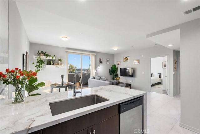 kitchen featuring dark brown cabinetry, light stone countertops, sink, and stainless steel dishwasher