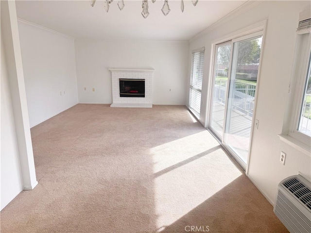 unfurnished living room featuring light carpet, a healthy amount of sunlight, and crown molding